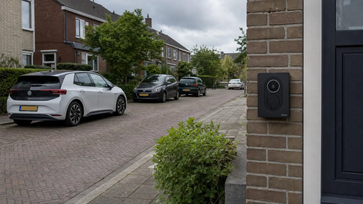 Laadpaal aan de gevel van een woning in een woonstraat met geparkeerde auto's